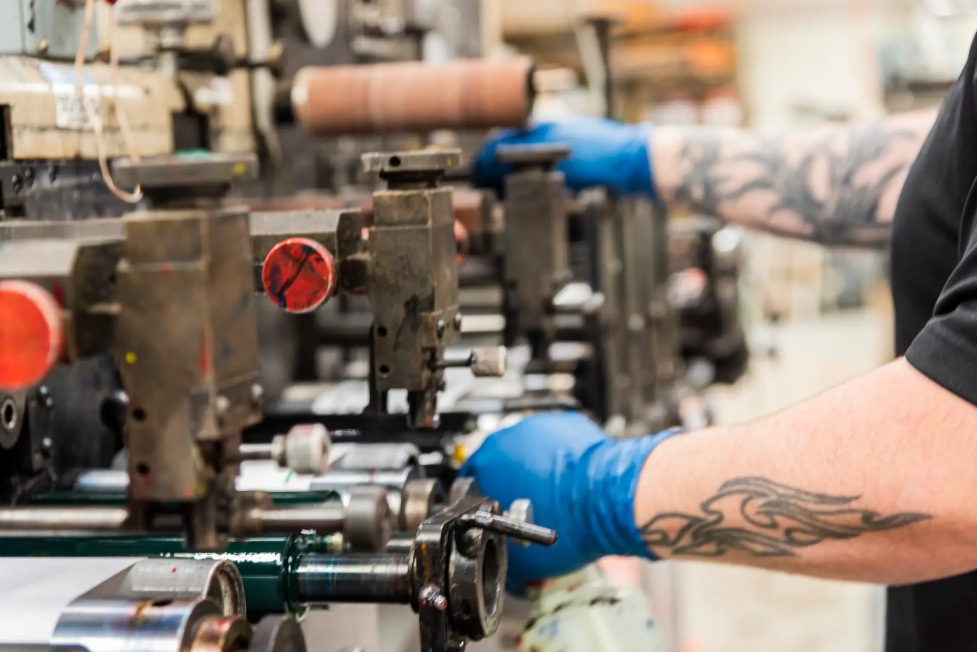 Close up of hands working on a Flexographic press